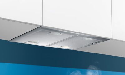 Unterbau-Dunstabzugshaube mit Beleuchtung vor blauem Hintergrund. Unterbau-Dunstabzugshaube mit Beleuchtung vor blauem Hintergrund.